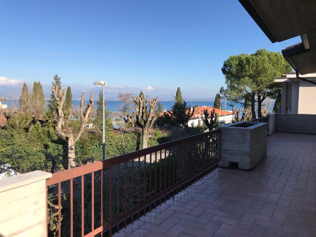 een balkon met uitzicht op de oceaan bij Casa Mary Tre - attico con terrazza a 2 passi dal lago in Sirmione