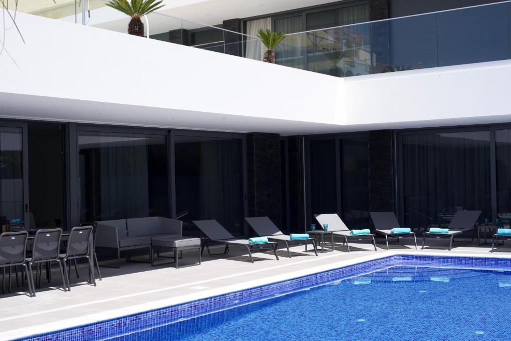 a building with a swimming pool and chairs and a building at Luxury Villa Aleana in Portimão