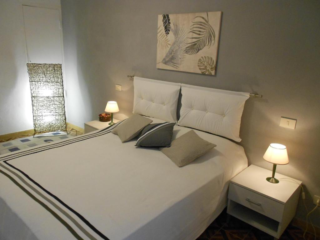 um quarto branco com uma cama branca com almofadas em Casa Giuly em Vivo dʼOrcia