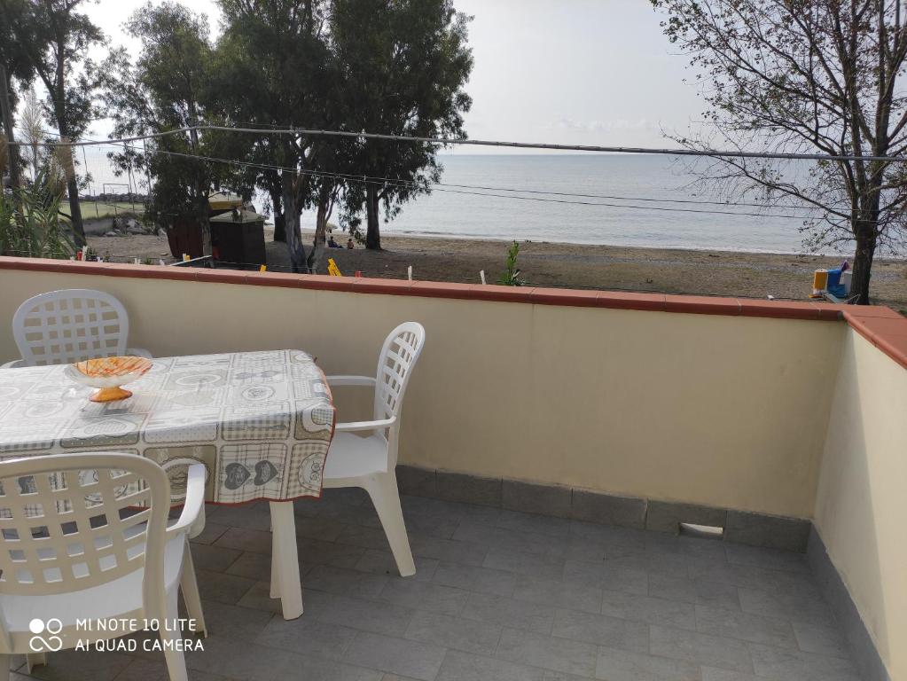 una mesa y sillas en un balcón con vistas al agua en Casa Rosa, en Capitello