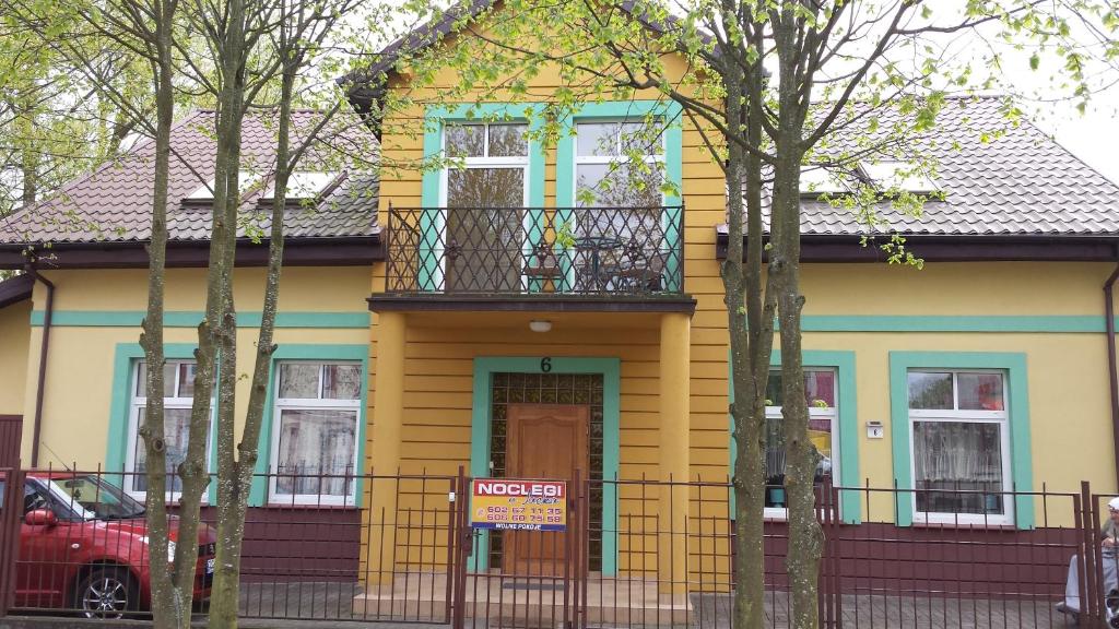 a yellow house with a balcony on top of it at Dom gościnny u Gerliz in Rewal