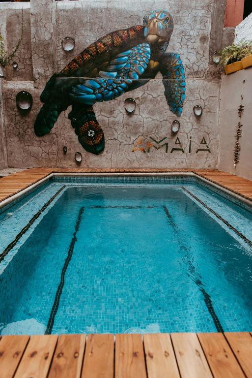 a swimming pool with a turtle on the wall at Amaia Boutique Hotel in Sayulita