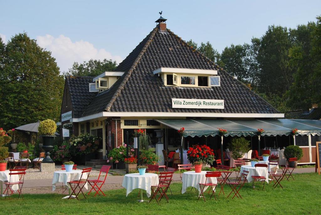 restauracja ze stołami i krzesłami przed budynkiem w obiekcie Villa Zomerdijk w mieście Velsen-Zuid
