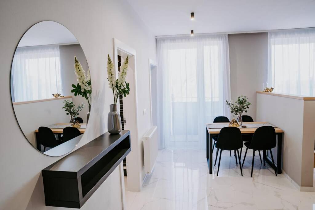 una sala da pranzo con specchio, tavolo e sedie di APARTMENT A&D Downtown a Poprad