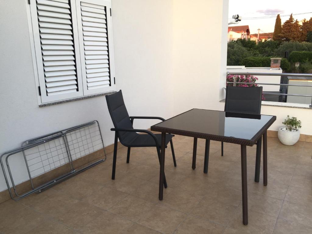 einen Tisch und Stühle in einem Zimmer mit Fenster in der Unterkunft Memories New Studio 200 m from beach in Pirovac