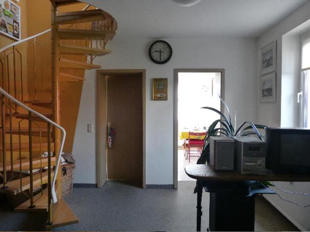 ein Zimmer mit einer Treppe und einer Uhr an der Wand in der Unterkunft Ferienwohnung Lehmann in Lunzenau