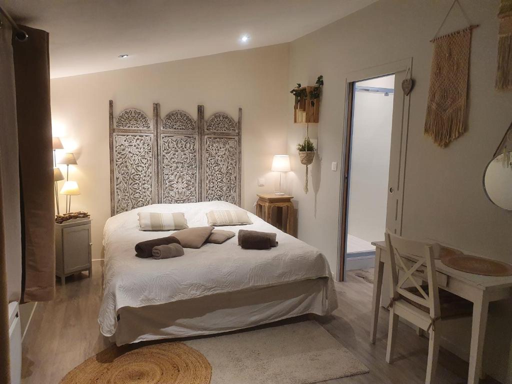 1 dormitorio con cama, mesa y espejo en Wisteria Cottage, en Fleurines