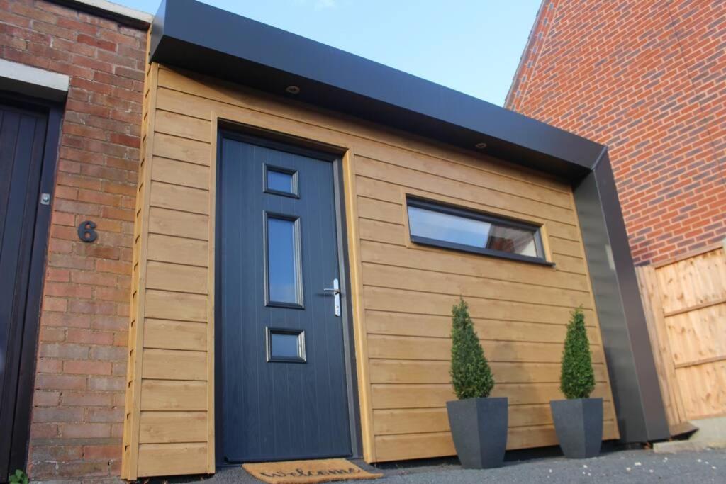 un garage avec une porte bleue et deux plantes dans l'établissement The Coneygree @ Northwick, à Worcester