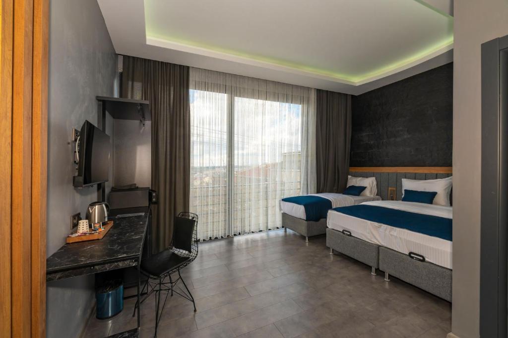 a hotel room with two beds and a television at Melanj Airport Hotel in Arnavutköy