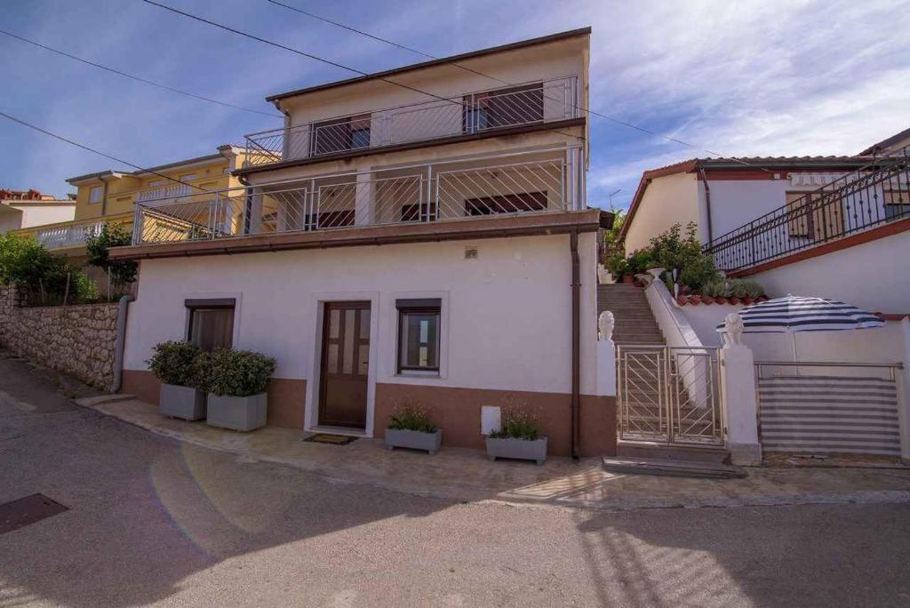 a large white house with stairs in front of it at Apartment in Vrbnik/Island Krk 35825 in Vrbnik