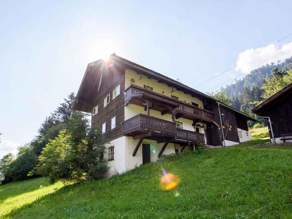 un bâtiment sur une colline avec un cerf-volant dans l'herbe dans l'établissement Holiday home in Mühlbach im Pinzgau 35597, à Dorf