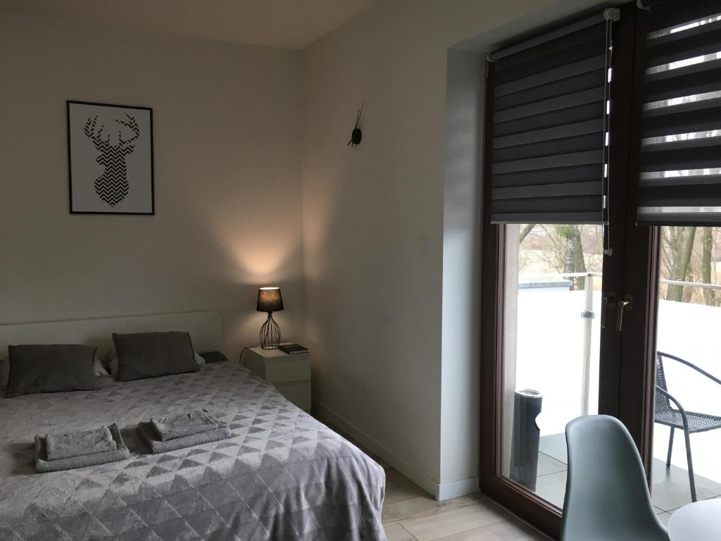 a bedroom with a bed and a sliding glass door at Studio Fibra Barista in Rybnik