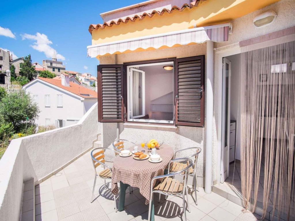 a small balcony with a table and chairs on a patio at Apartments in Vrbnik/Insel Krk 13611 in Vrbnik