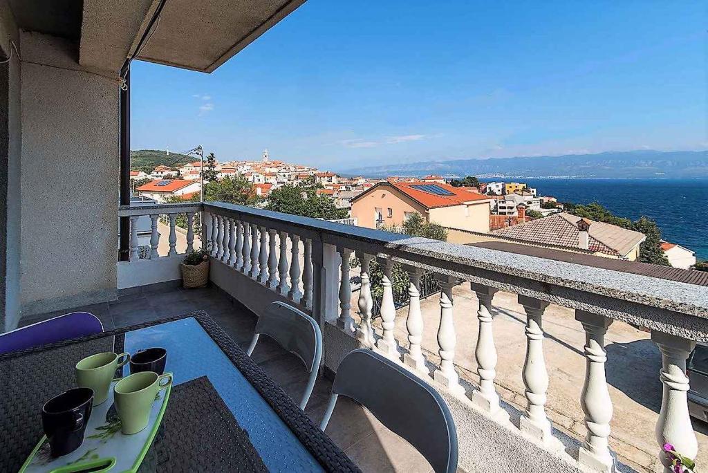 a balcony with a table and a view of the water at Apartment in Vrbnik/Insel Krk 13616 in Vrbnik