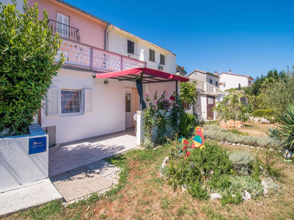 a house with a red umbrella in front of it at Apartment in Vrbnik/Insel Krk 13614 in Vrbnik