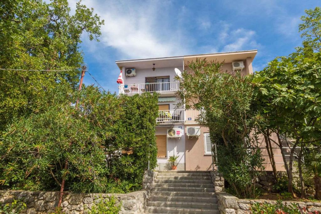 a building with stairs and trees in front of it at Apartment in Crikvenica 5611 in Sopaljska