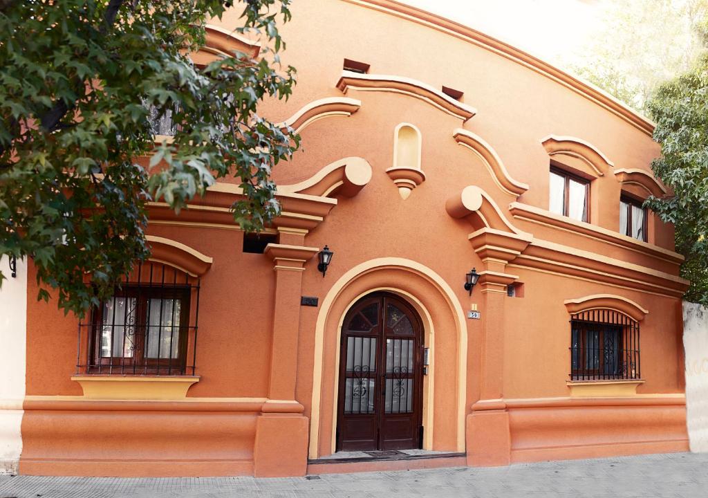 an orange building with two windows and a door at Donna Alda Casa in Salta