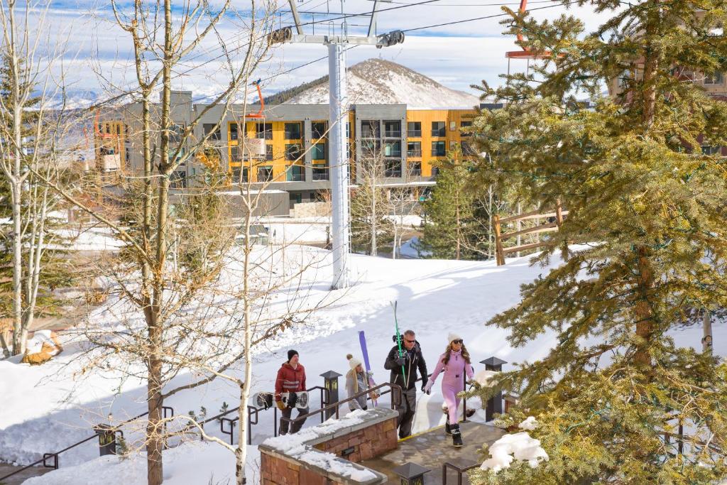 Un groupe de personnes marchant dans la neige dans l'établissement YOTELPAD Park City, à Park City