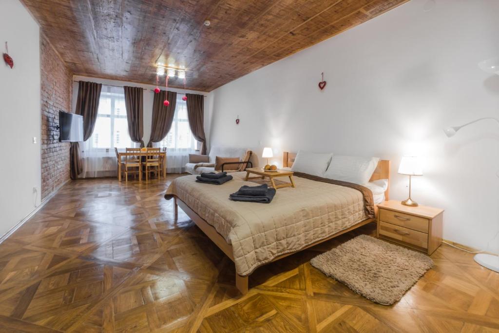 1 dormitorio con 1 cama y sala de estar en Luxury apartment with Rynok square view, en Leópolis