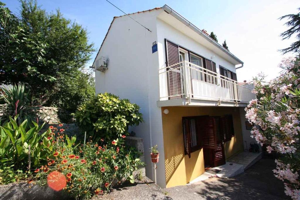 a white house with a balcony and some flowers at Apartment in Silo/Insel Krk 14461 in Šilo