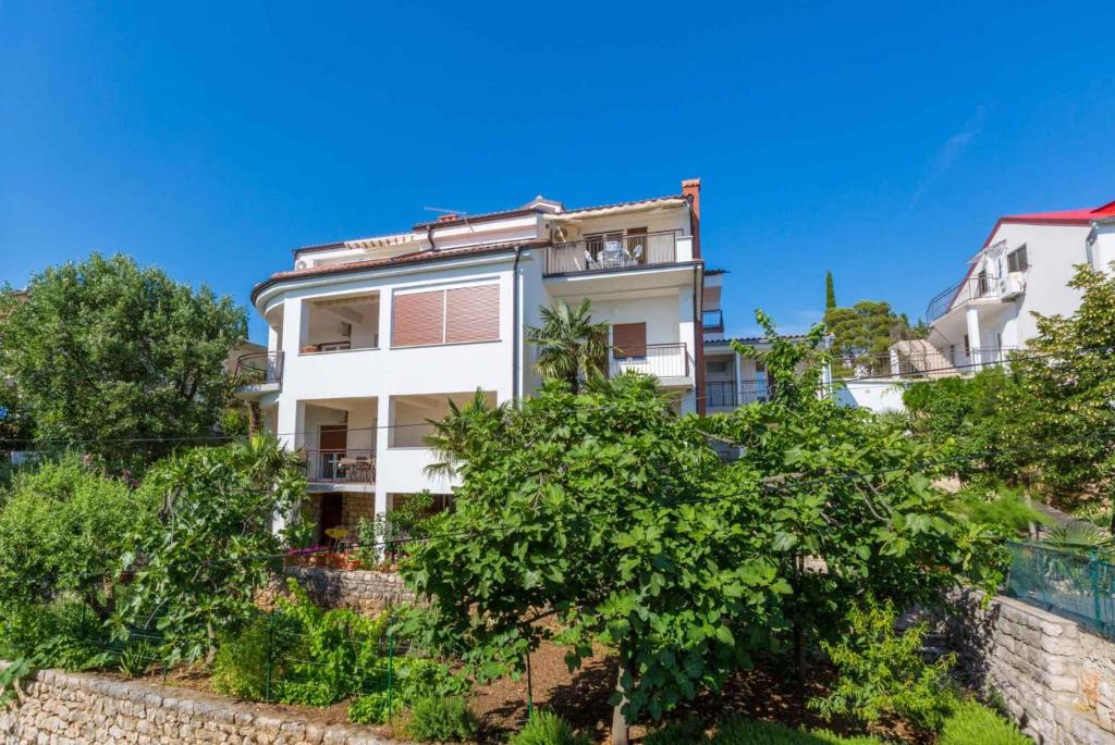 a white building with trees in front of it at Apartment in Crikvenica with One-Bedroom 6 in Dramalj