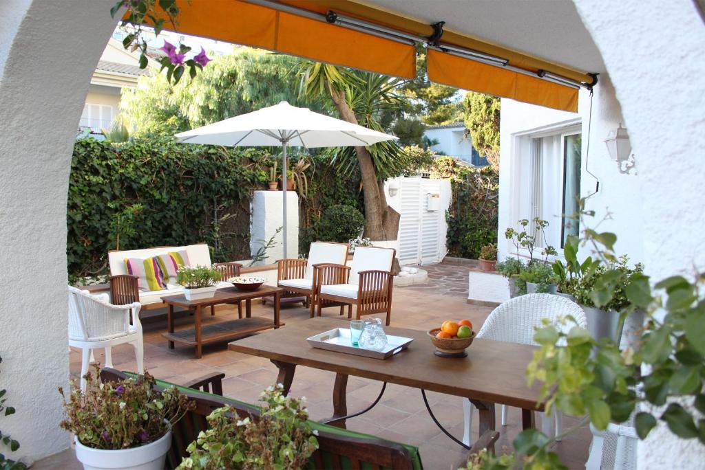 a patio with a table and chairs and an umbrella at Casa en Sitges in Sitges