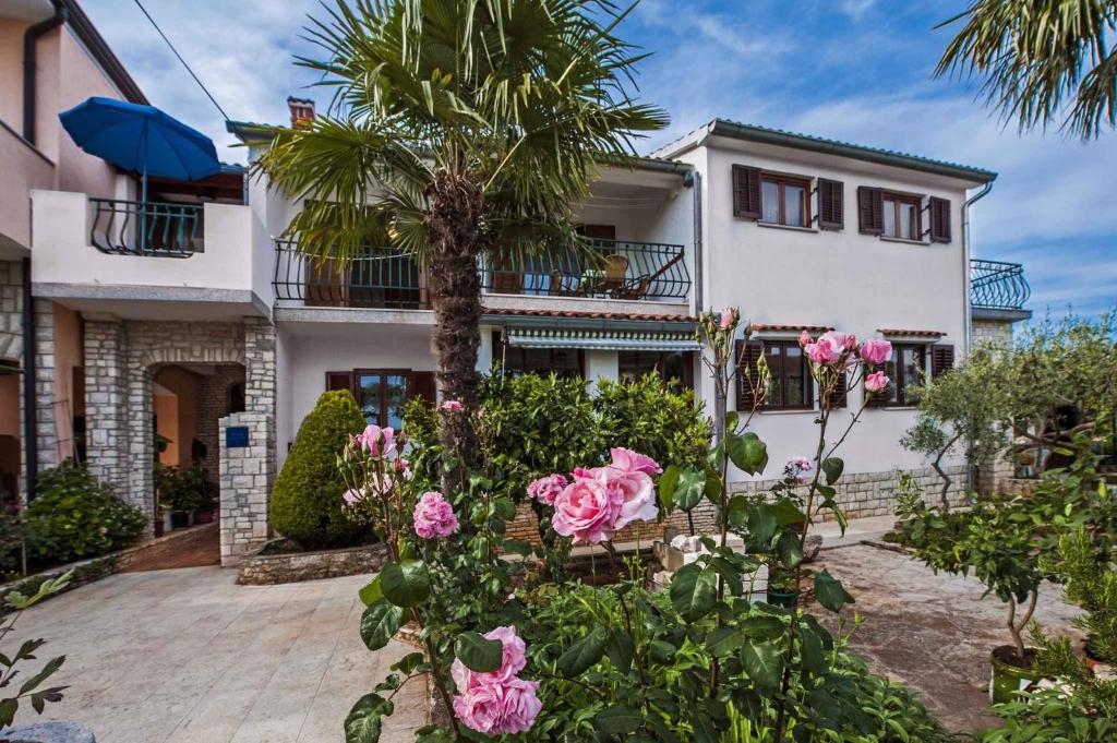 a house with a palm tree and pink roses at Apartment in Rovinj/Istrien 11561 in Štanga