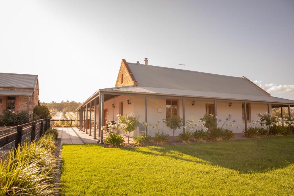 ein weißes Haus mit einem Zaun und einem Hof in der Unterkunft Brockenchack Vineyard Bed & Breakfast in Mount McKenzie