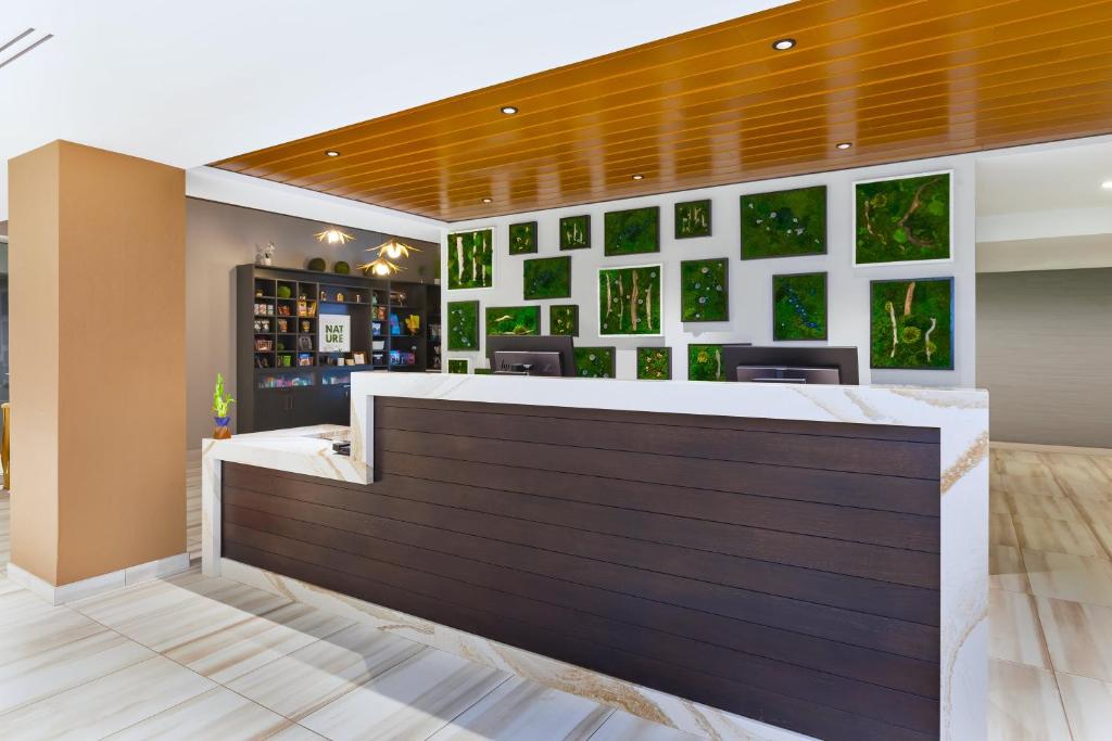 a bar with green pictures on the wall at Hotel Indigo Rochester - Mayo Clinic Area in Rochester