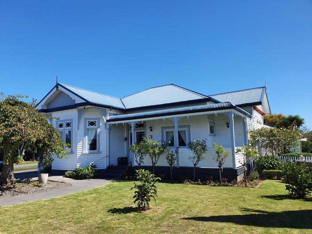 a white house with a gambrel roof at Fossil Coast B&B in Hawera