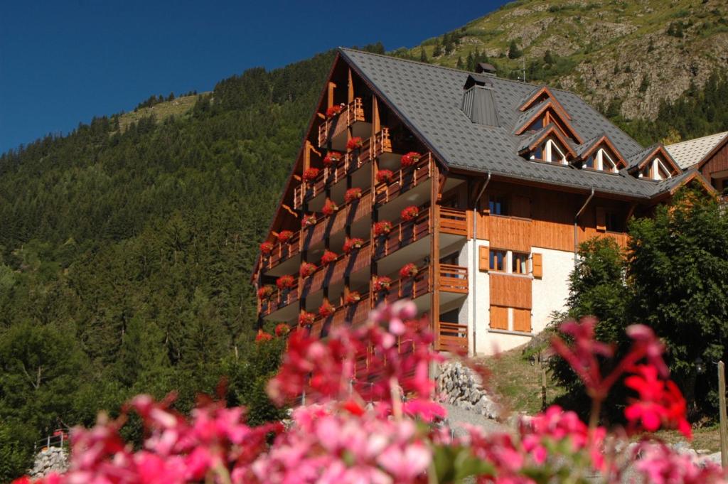a building with balconies on the side of it with flowers at Chalet La Perle de L'Oisans - Appartements d'Exception in Vaujany