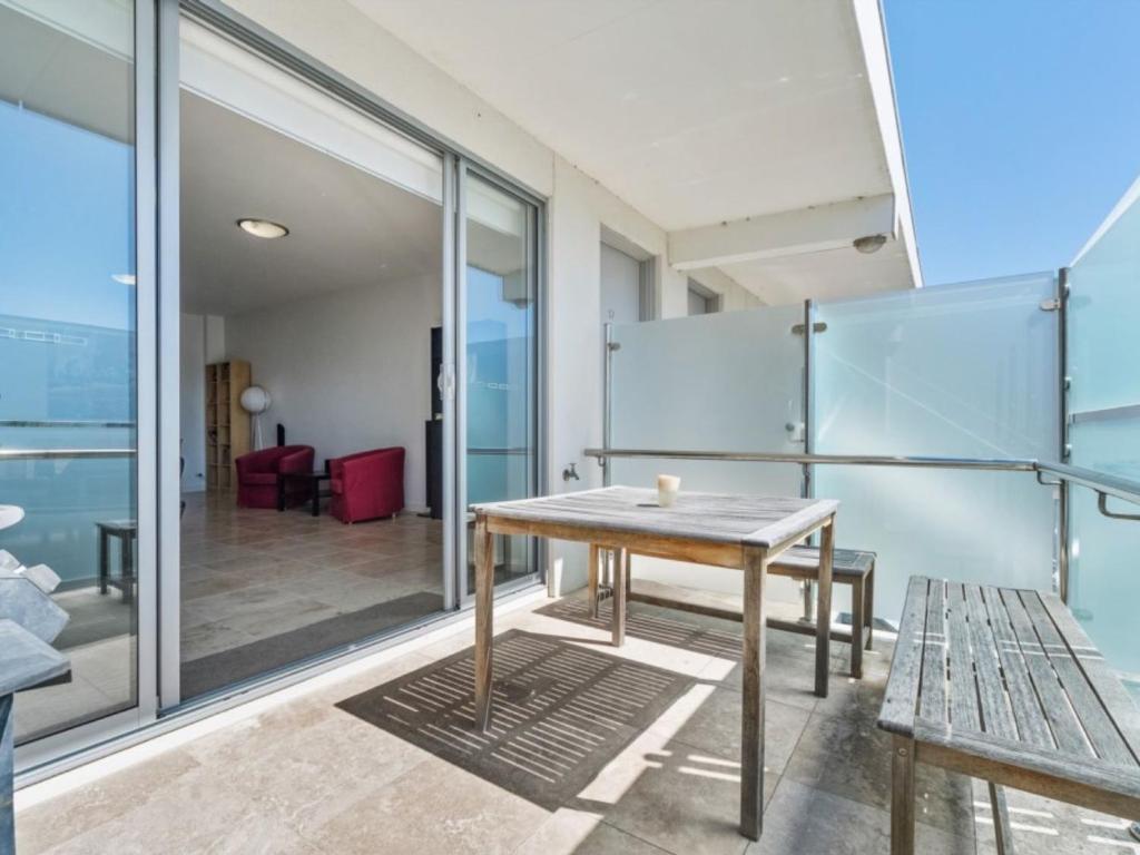 mesa y banco en una habitación con paredes de cristal en Coastal Downtown Dromana, en Dromana