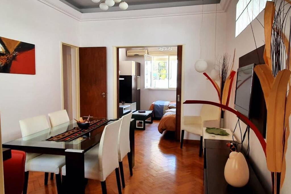 uma sala de estar com uma mesa de jantar e uma sala de estar com um sofá em Corazón Porteño em Buenos Aires
