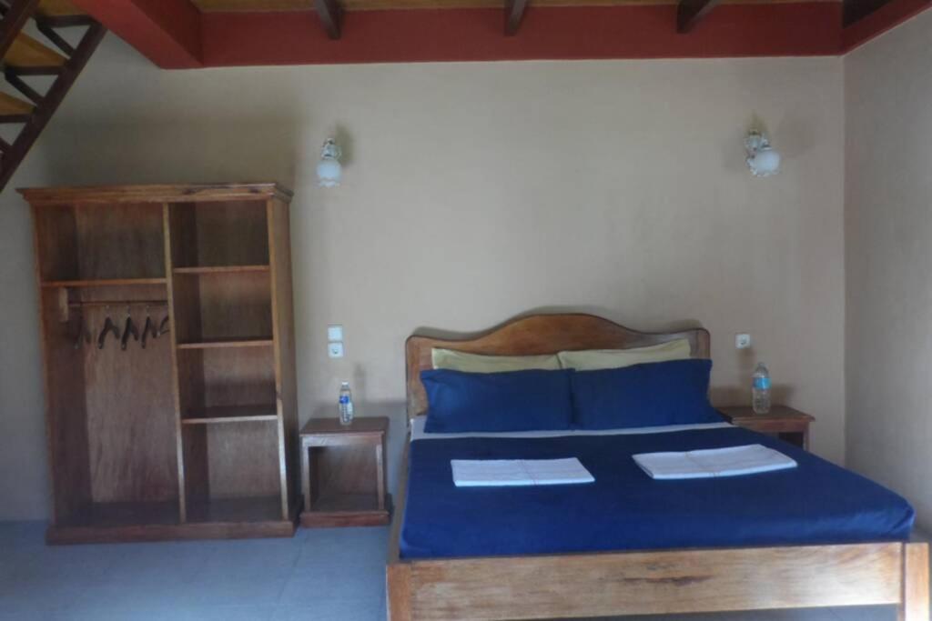 a bedroom with a bed with blue sheets and wooden furniture at Beach House Sibuyan via Cresta de Gallo in San Fernando