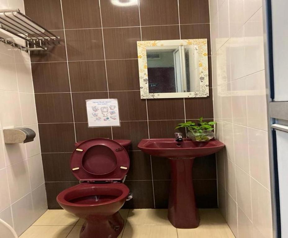 a bathroom with a red toilet and a sink at Ct Hotel in Sitiawan