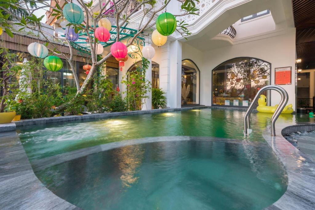 an indoor swimming pool in a building with a swimming pool at Hoang Trinh Hotel in Hoi An