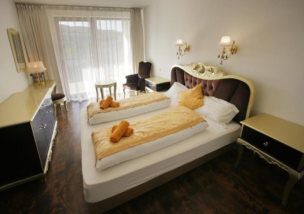 a bedroom with two beds with brown comforters at Garden Hotel Domaša in Domaša Dobrá
