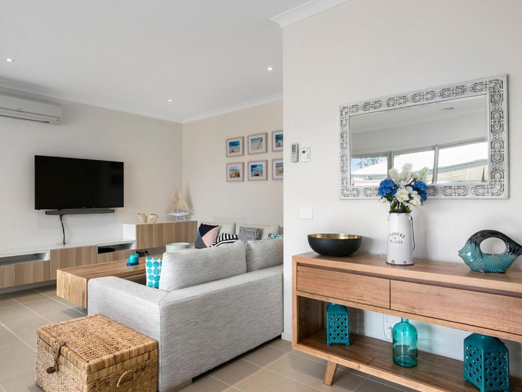 a living room with a couch and a tv at Rosebay Walk To The Foreshore in Capel Sound