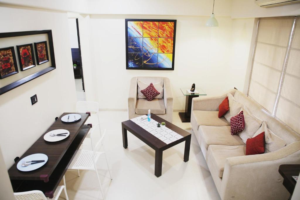 a living room with a couch and a table at Lite Stays - Vile Parle East in Mumbai