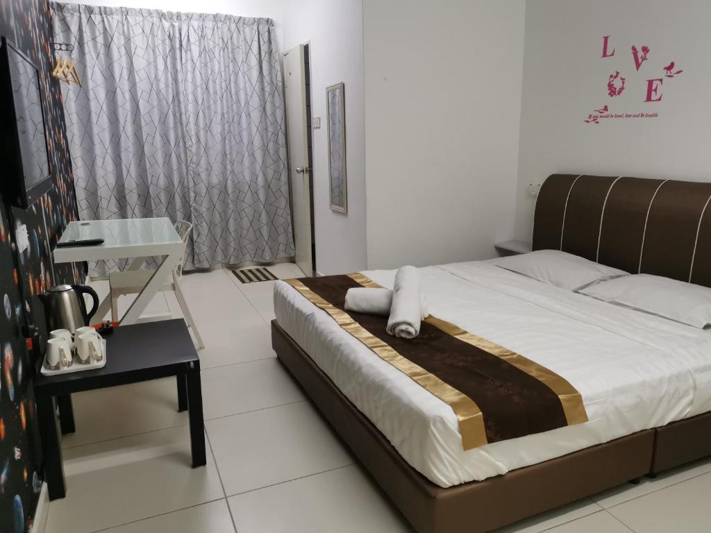 1 dormitorio con cama, mesa y ventana en Melaka Stay, en Melaka