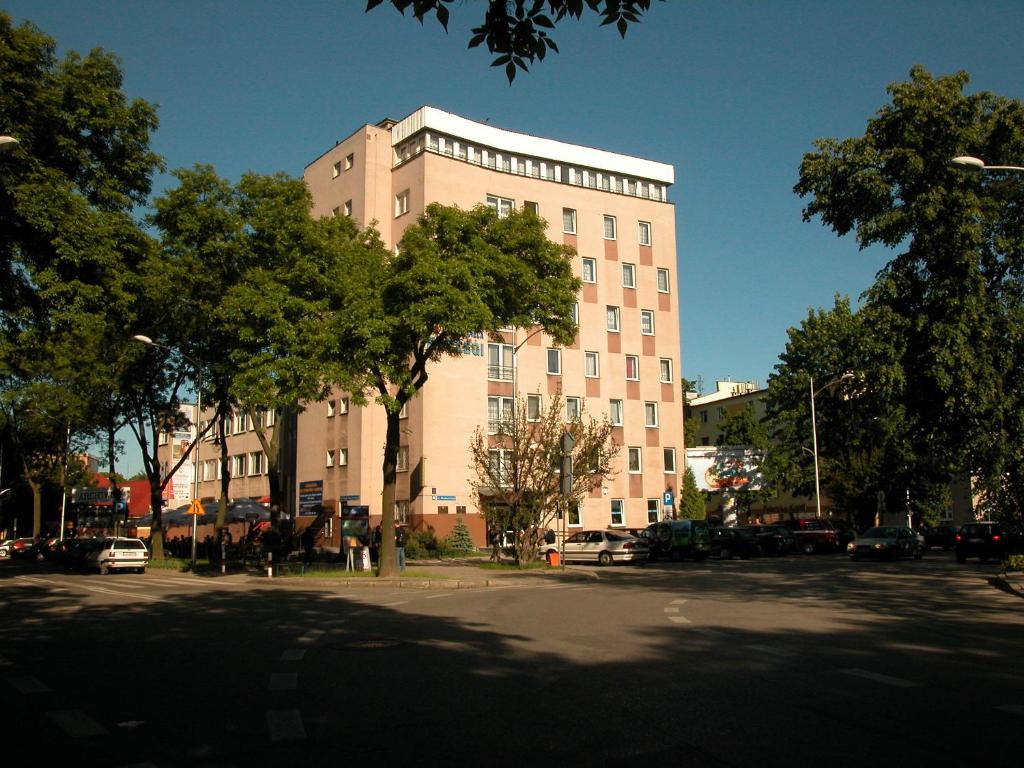 un gran edificio con un árbol delante en Hotel Logos, en Lublin