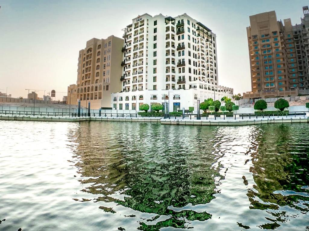 een groot gebouw naast een grote hoeveelheid water bij Suha Creek Hotel Apartment, Waterfront Jaddaf, Dubai in Dubai