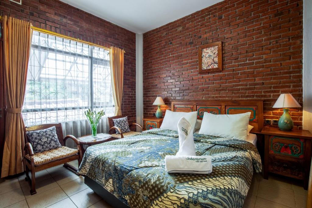 um quarto com uma cama e uma parede de tijolos em Sekararum Butik Syariah Guesthouse em Bandung