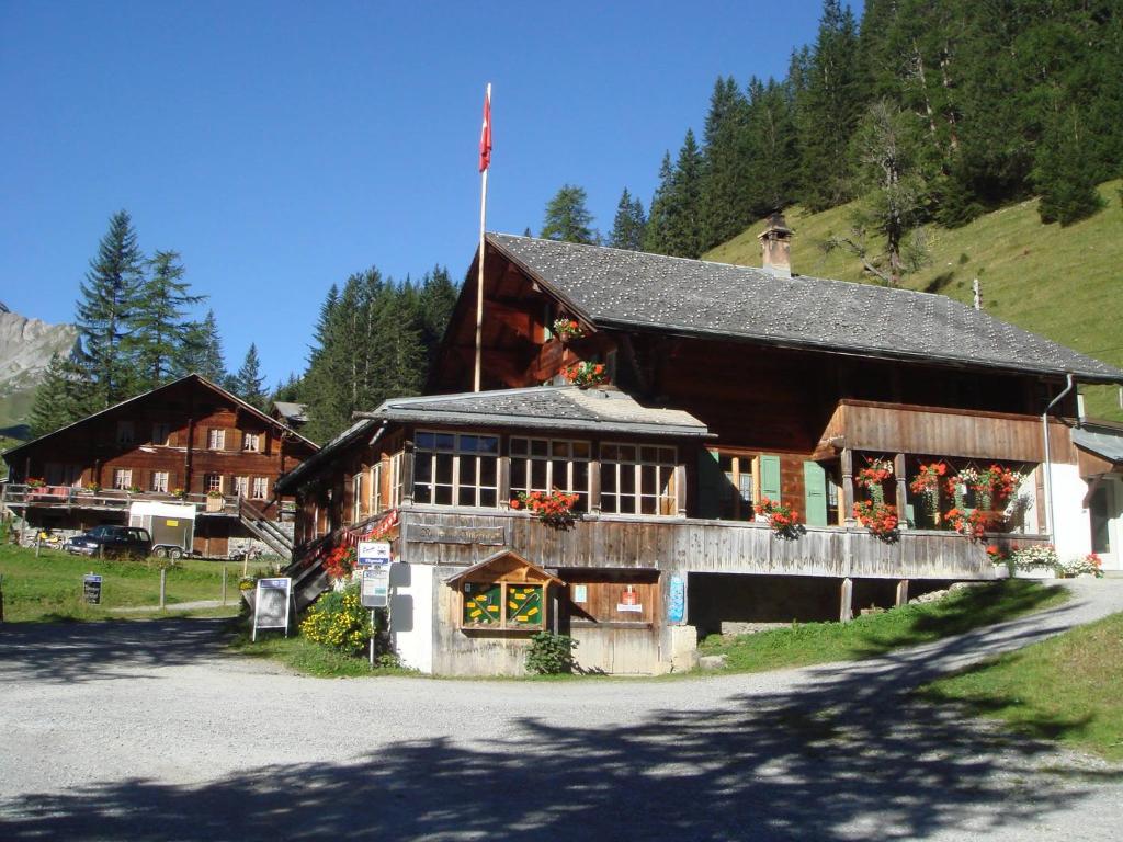a large building with a flag on top of it at Berghaus Iffigenalp in Lenk