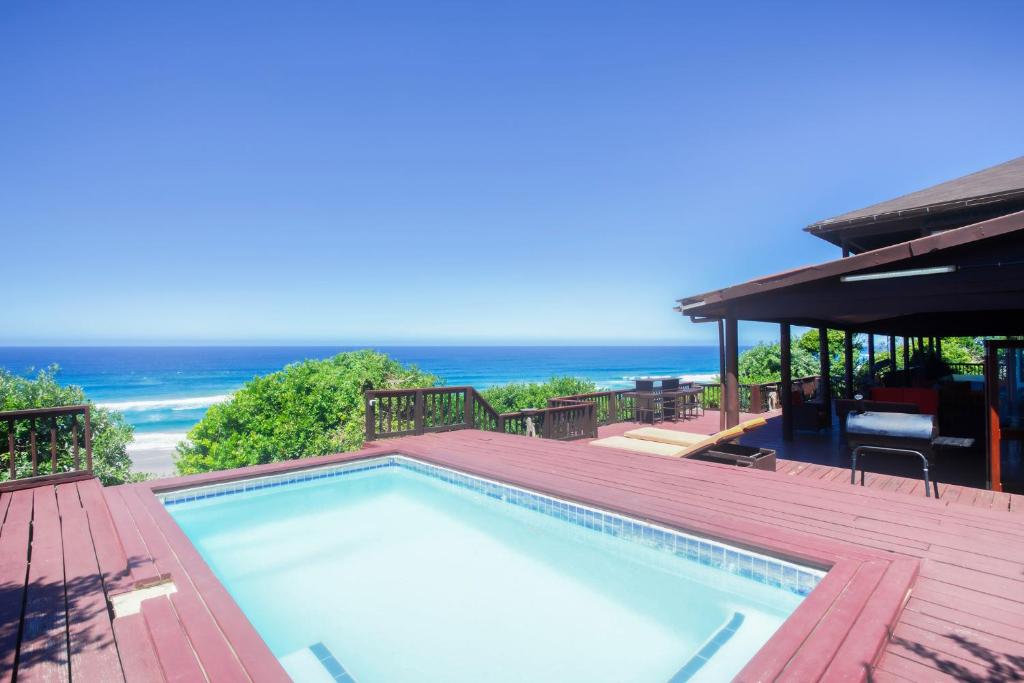 a swimming pool on a deck with the ocean in the background at Mar Azul 2 in Ponta Malongane