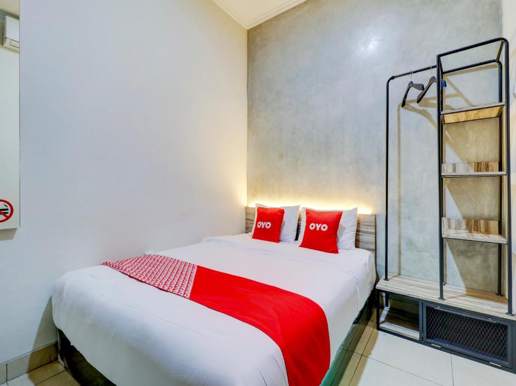 a bedroom with a large bed with red pillows at OYO 90215 Ada Residence in Poponcal 2