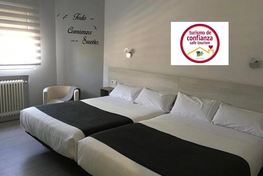 1 dormitorio con 2 camas y un cartel en la pared en Hostal I Dream Salamanca, en Salamanca