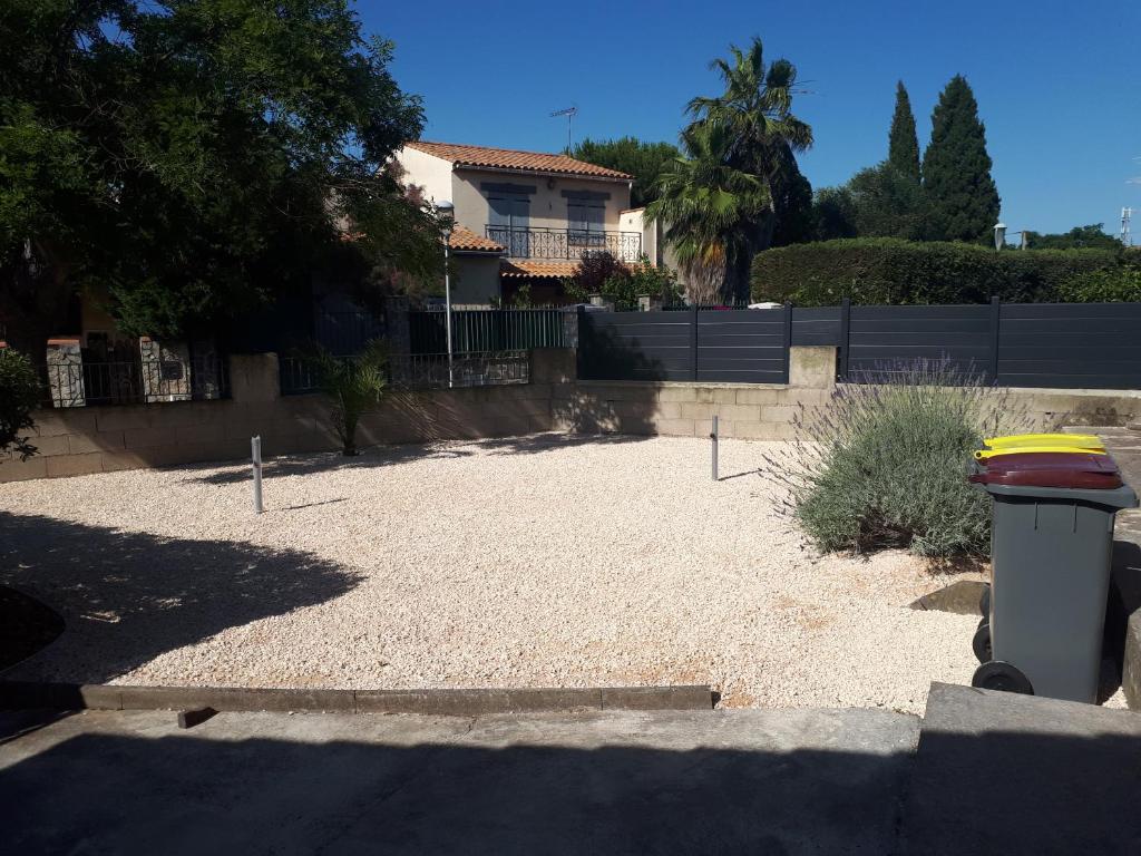 einen Hof mit einem Mülleimer vor einem Haus in der Unterkunft Leo's Chambres d'Hôte in Agde