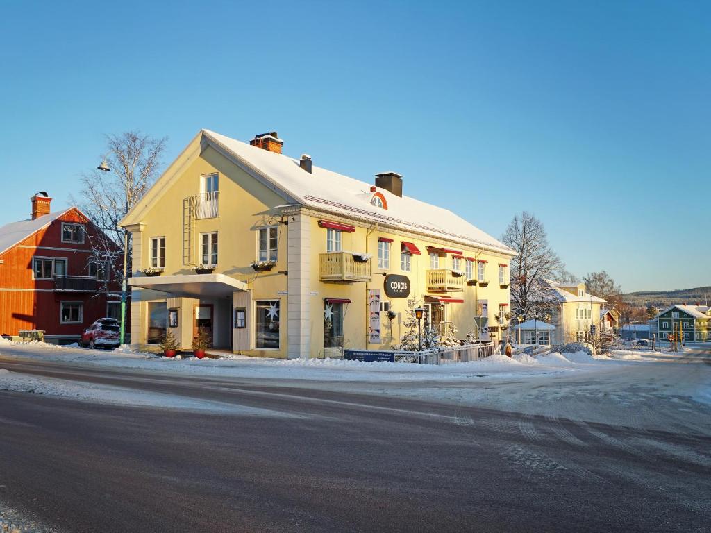 a yellow building on the side of a street at Condis Lägenheten in Järvsö