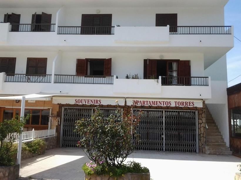 a white building with a sign that reads at Apartment Torres Mari in Cala Llonga